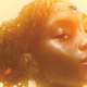 A Black woman with her hair up and a cybernetic implant that looks like a jewel on her forehead looks sideways from the cover of Nnedi Okorafor's Noor.